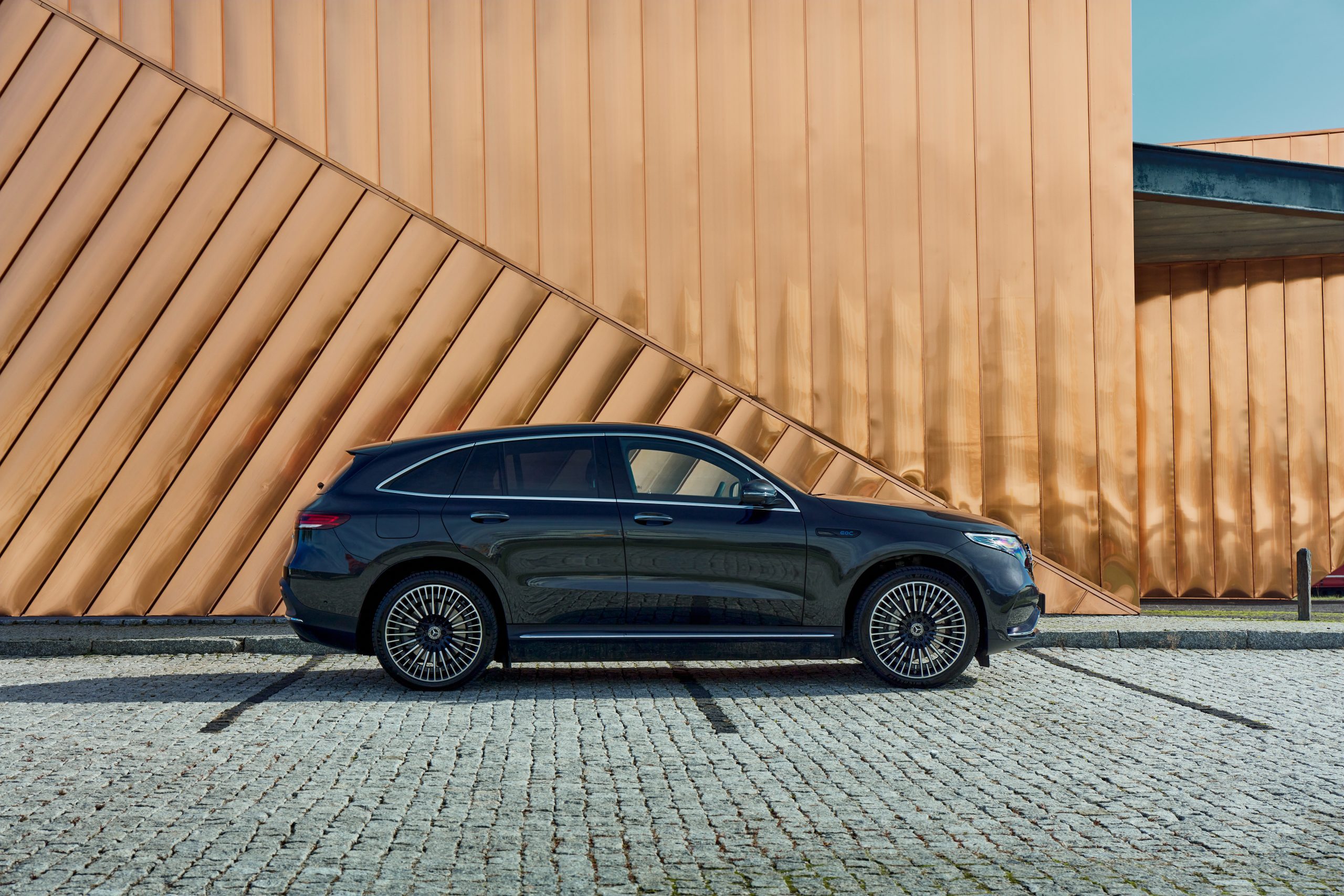 Electric Mercedes Eqc Standing Against The Golden Wall Of The Fire Museum. The Car Has A 408hp Engine And Accelerates 0 100 Km H In 5.1 Seconds. Range (wltp) 369 414 Km. Zory, Poland, 10.06.2020