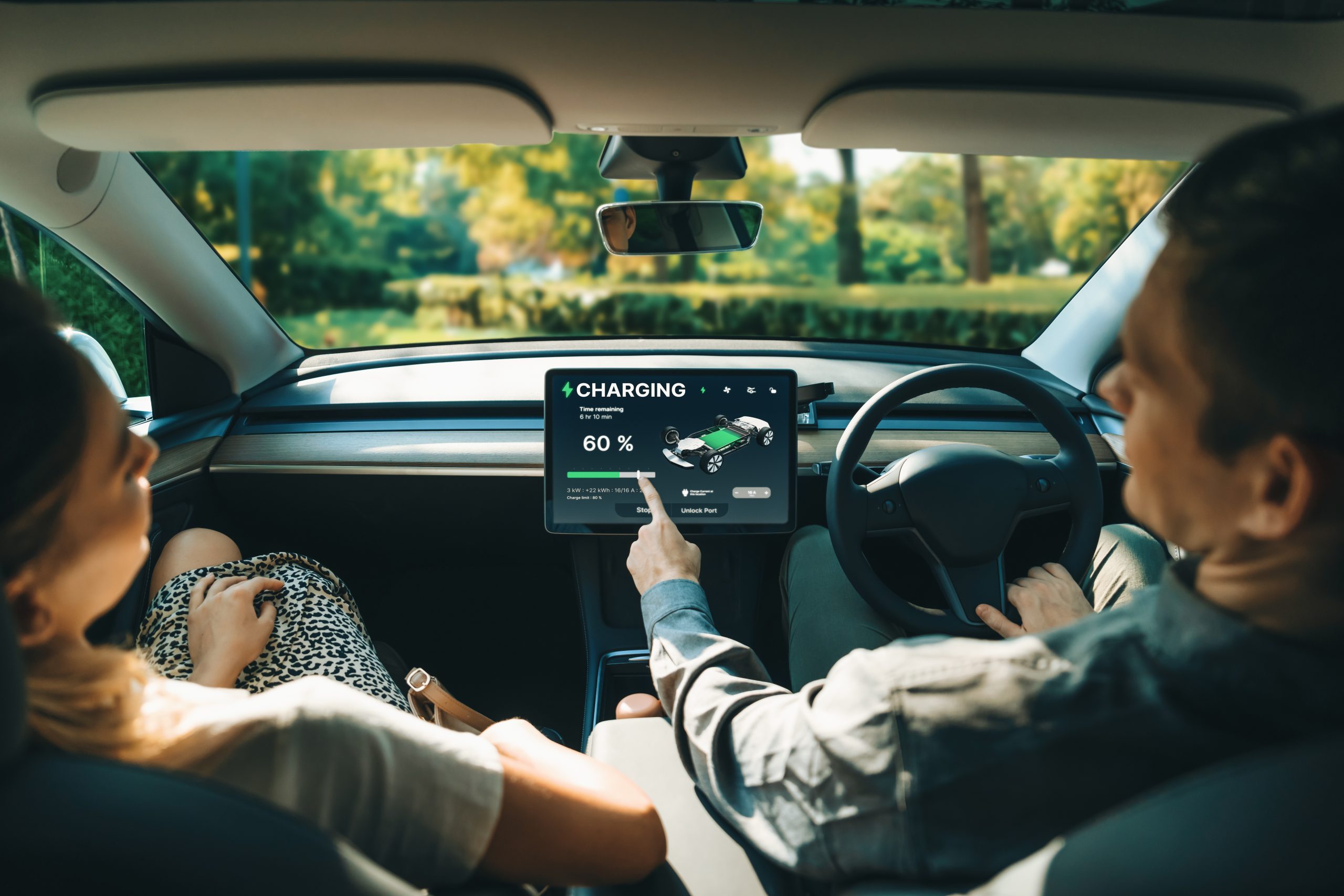 Electric Car Driver Checks Battery Charging Status App Screen In Car Innards